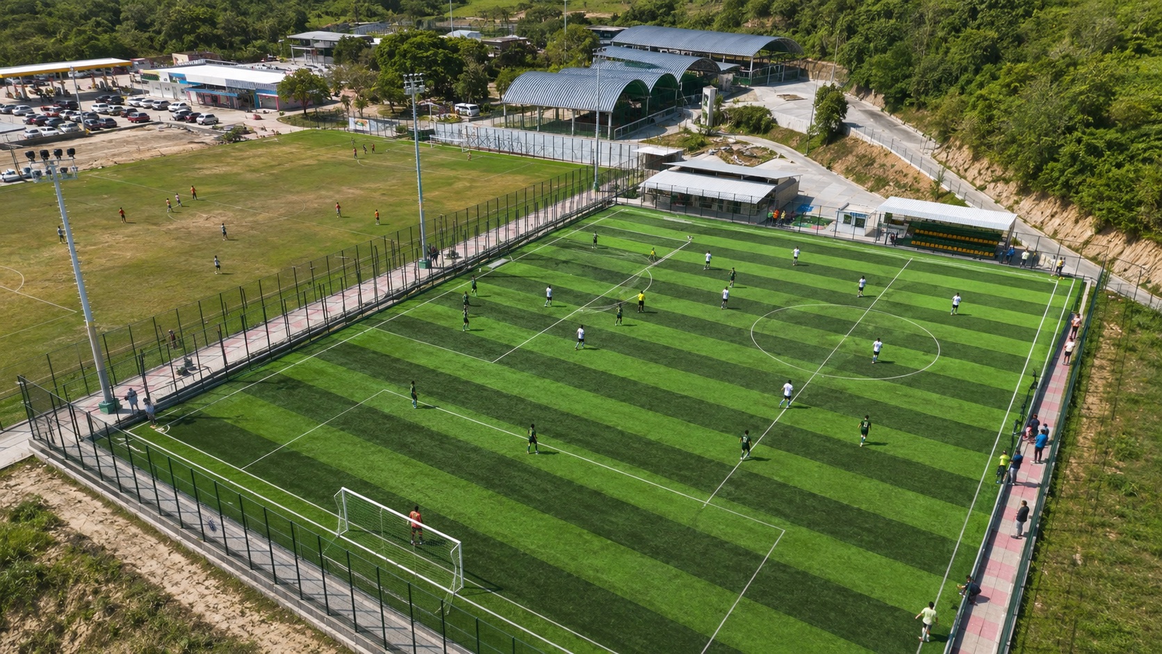 Jugadores disputando balon en cancha de futbol sintetica